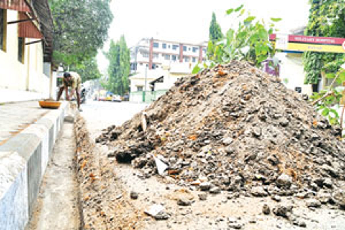 A CCP worker cleans up a drain as part of the pre-monsoon clean-up drive