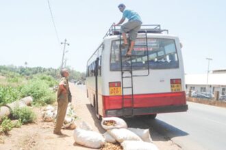 A Karnataka state transport bus unloads vegetable stocks near the Polem border.