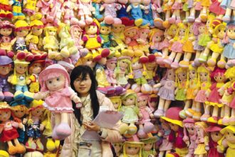 A booth holder holds a toy doll at the Toys and Games Fair in Hong Kong on Monday.