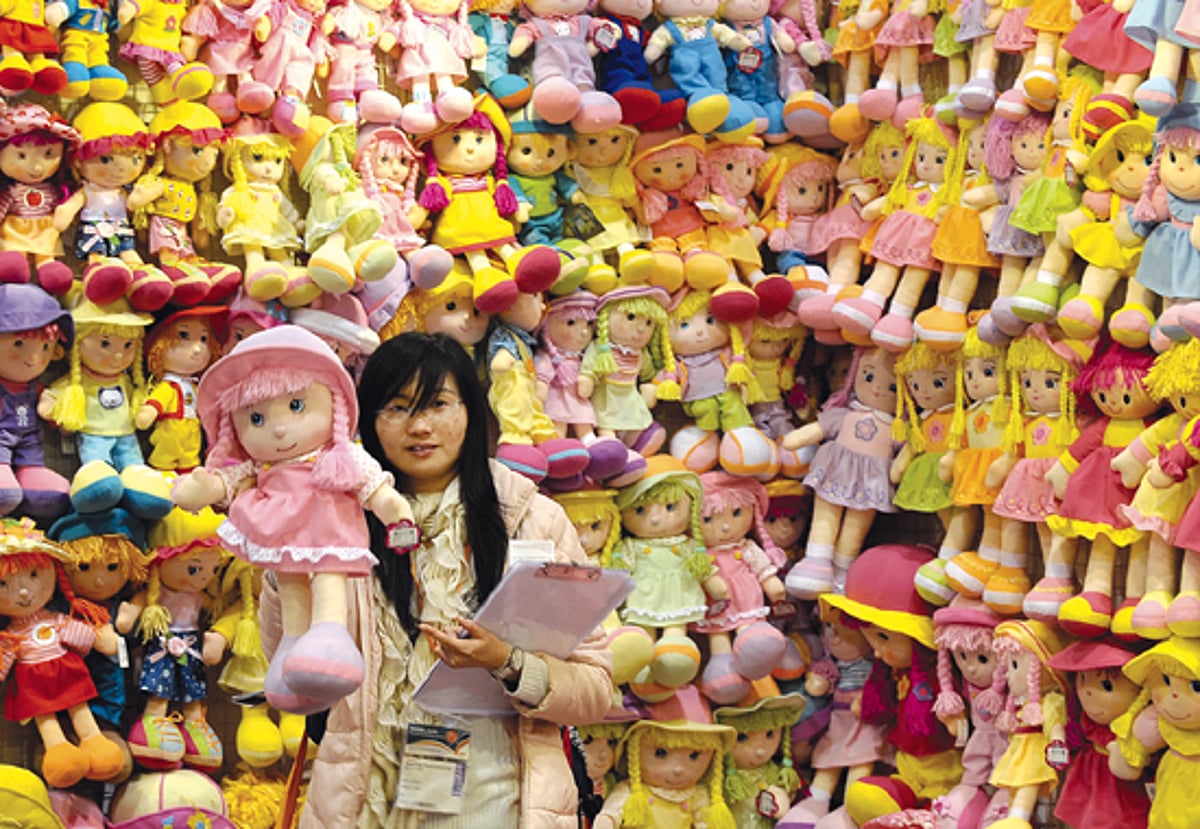 A booth holder holds a toy doll at the Toys and Games Fair in Hong Kong on Monday.