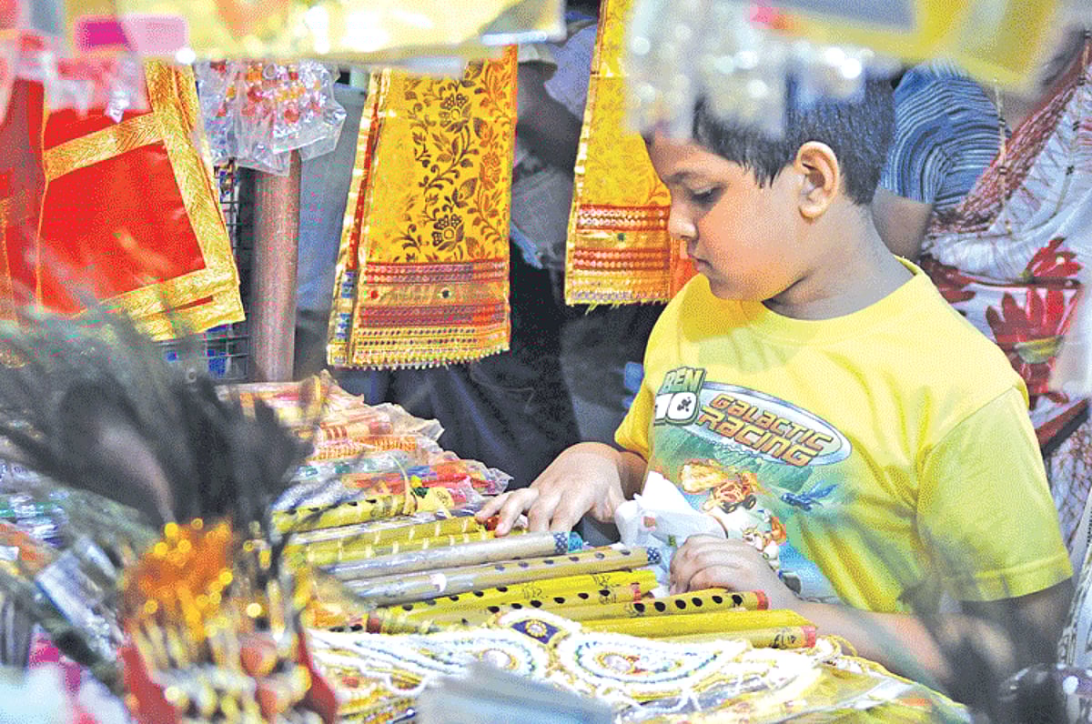 A boy selects a flute along with costumes displayed for sale at the Panjim market on Monday. Gokulashtami which marks the birth of Lord Krishna will be celebrated on August 28.