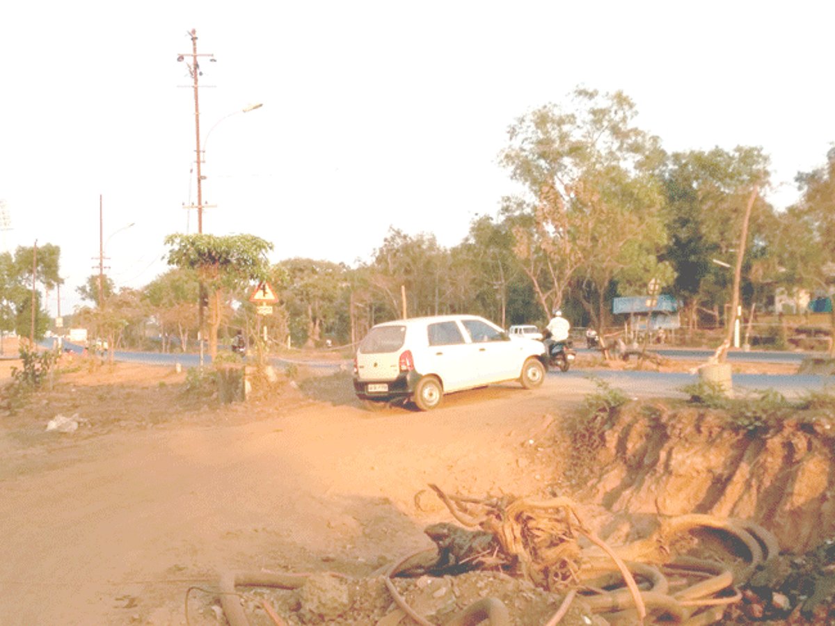 A car leaving from GARD hostel makes its way up the makeshift mud ramp onto the highway with speeding traffic, attempts to cross over and go to the GMC.