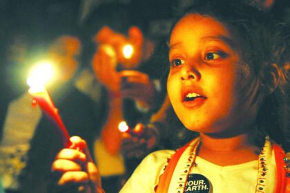 A child lights candles during an Earth Hour campaign in Mumbai on Saturday.  Dozens of Indians and citizens world-wide lit candles to observe Earth Hour and called for voluntary action against climate change.