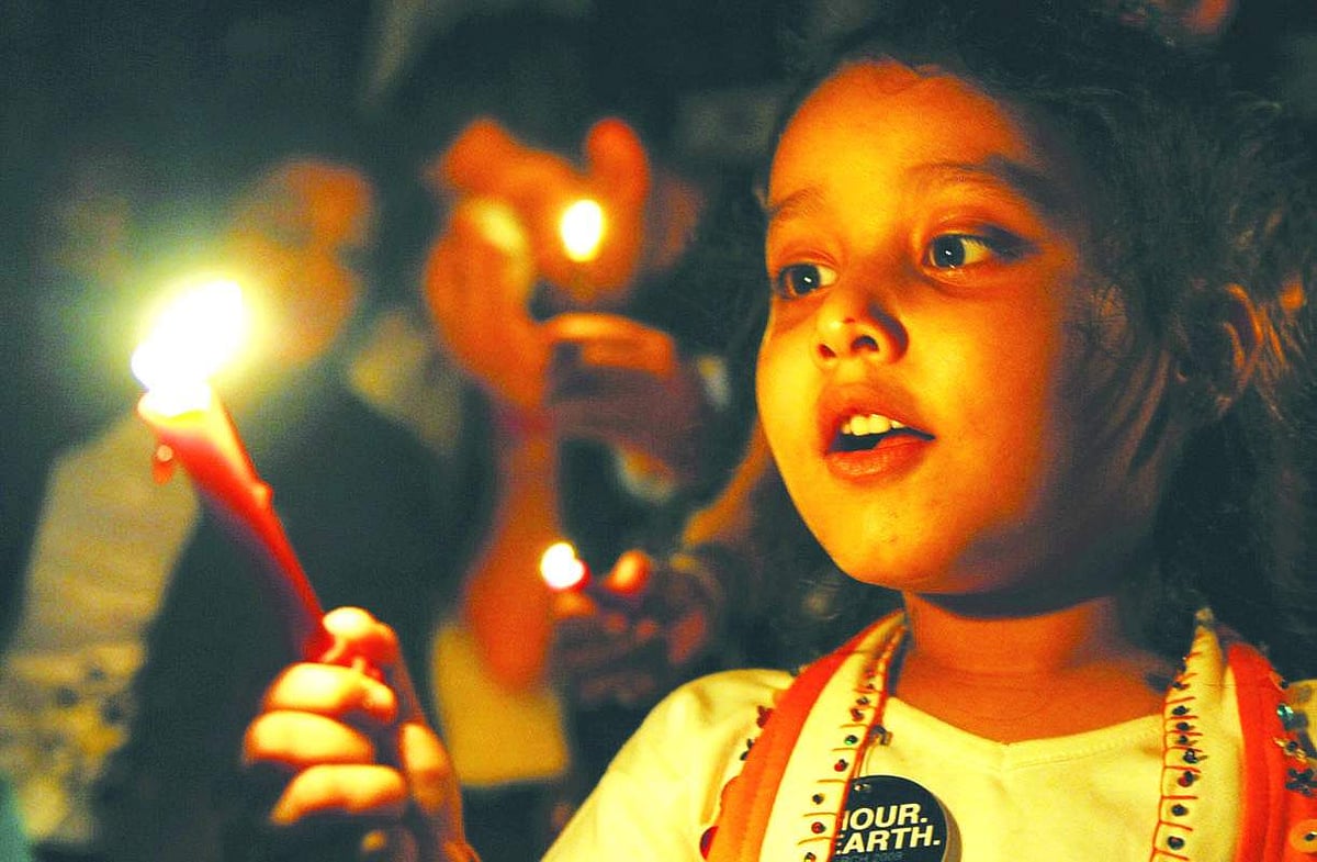 A child lights candles during an Earth Hour campaign in Mumbai on Saturday.  Dozens of Indians and citizens world-wide lit candles to observe Earth Hour and called for voluntary action against climate change.