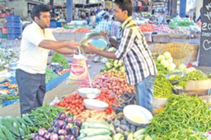 A customer buys vegetables at the Ponda market.