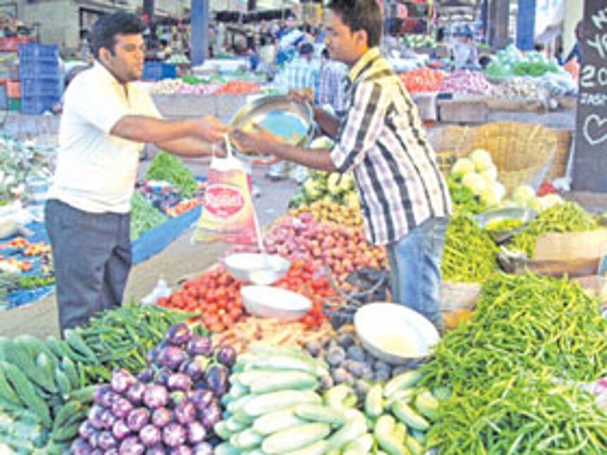 A customer buys vegetables at the Ponda market.