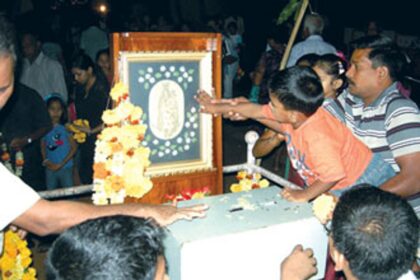 A devotee helping his child to seek blessings of Our Lady of Health