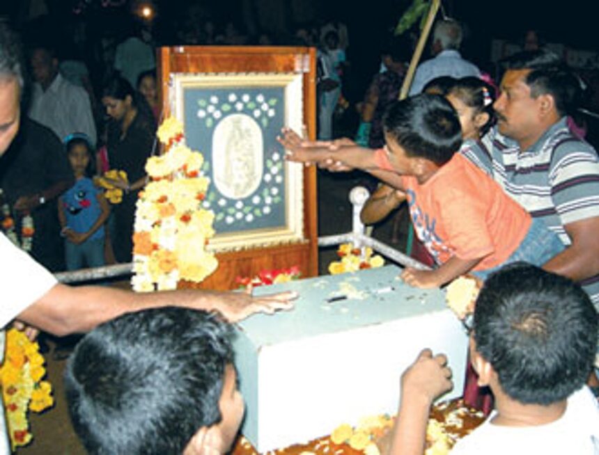 A devotee helping his child to seek blessings of Our Lady of Health