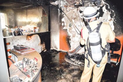 A firefighter of the Goa State Fire Force checks the remains after a fire gutted a clinic