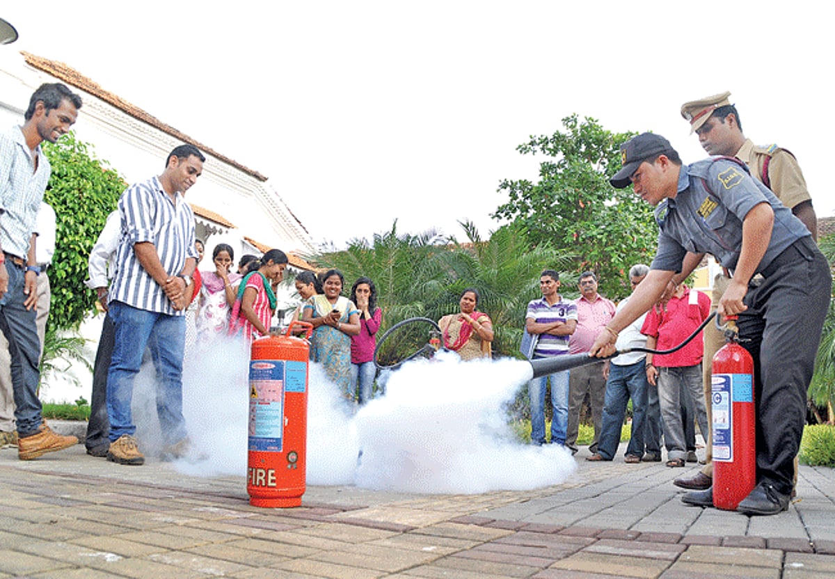 A firefighter shows security guard, staff and volunteers of ESG on how to use a fire extinguisher at a demonstration and mock drill held in preparation for the IFFI 2013 in Panjim on Monday.