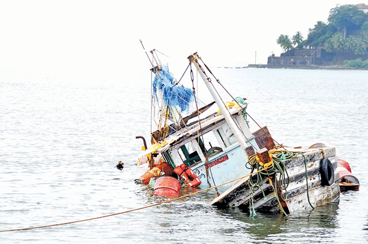 A fishing trawler lies half submerged in water along the banks of river Mandovi after it developed a technical snag in its engine.