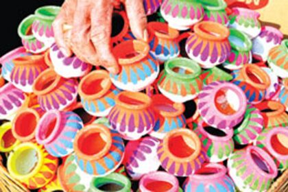A local vendor arranges colourful earthen mini pots for Haldi Kumkum ceremony