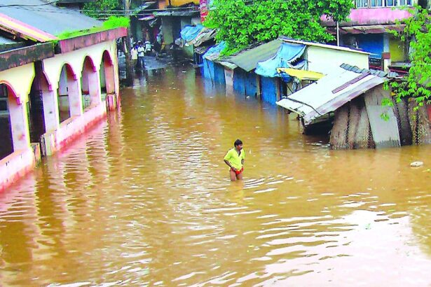 A man walks in knee-deep water in Sanquelim market.
