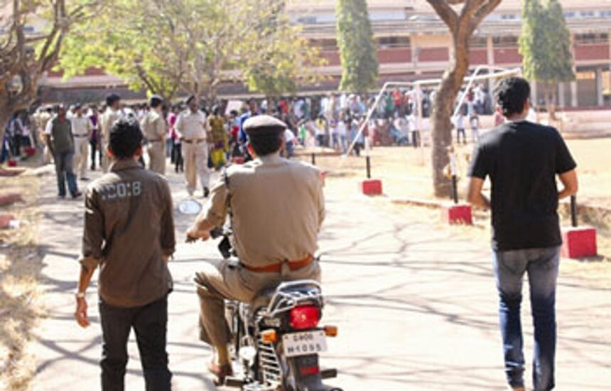 A policeman proceeds to the school campus, as parents protest against the sexual assault on a 7-year-old schoolgirl.