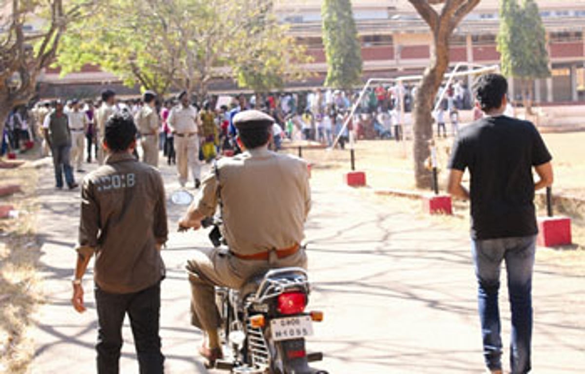 A policeman proceeds to the school campus, as parents protest against the sexual assault on a 7-year-old schoolgirl.