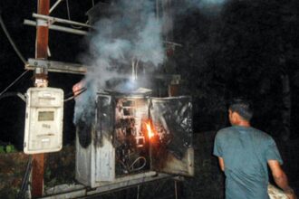 A resident tries to extinguish the fire which engulfed the 100 KVA transformer