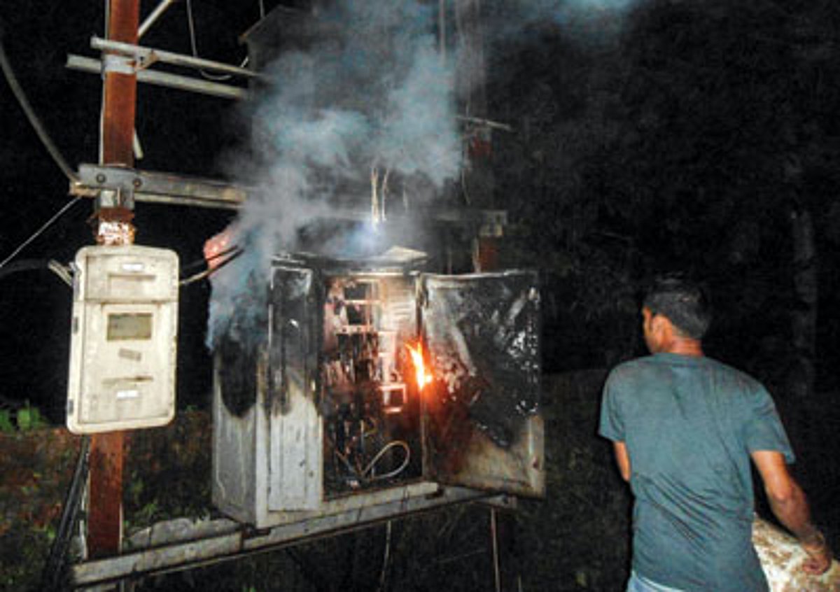 A resident tries to extinguish the fire which engulfed the 100 KVA transformer