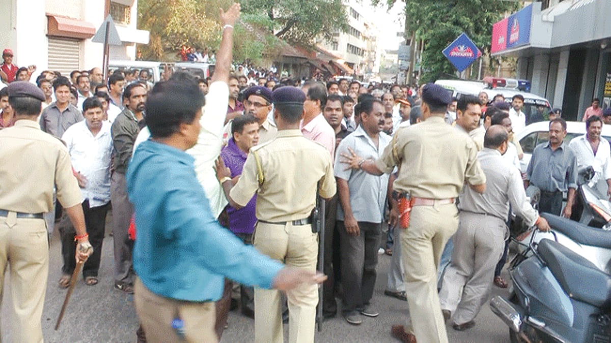 A small number of policemen struggling to keep the agitated people from the mining