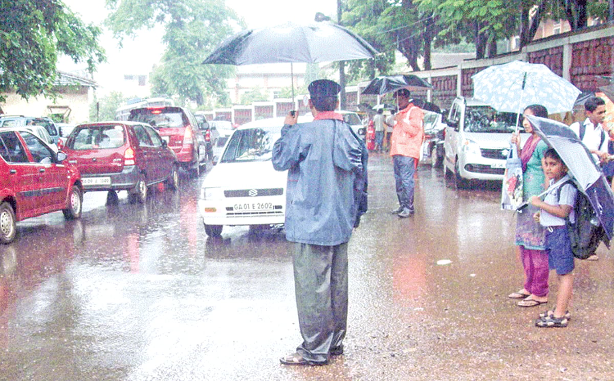 A student and his mother wait for an opportunity to cross the road in Ponda