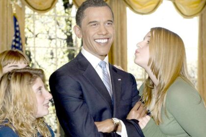 A visitor to Madame Tussaud's New York pretends to kiss wax figure of US President-elect Barack Obama on Thursday in New York City.