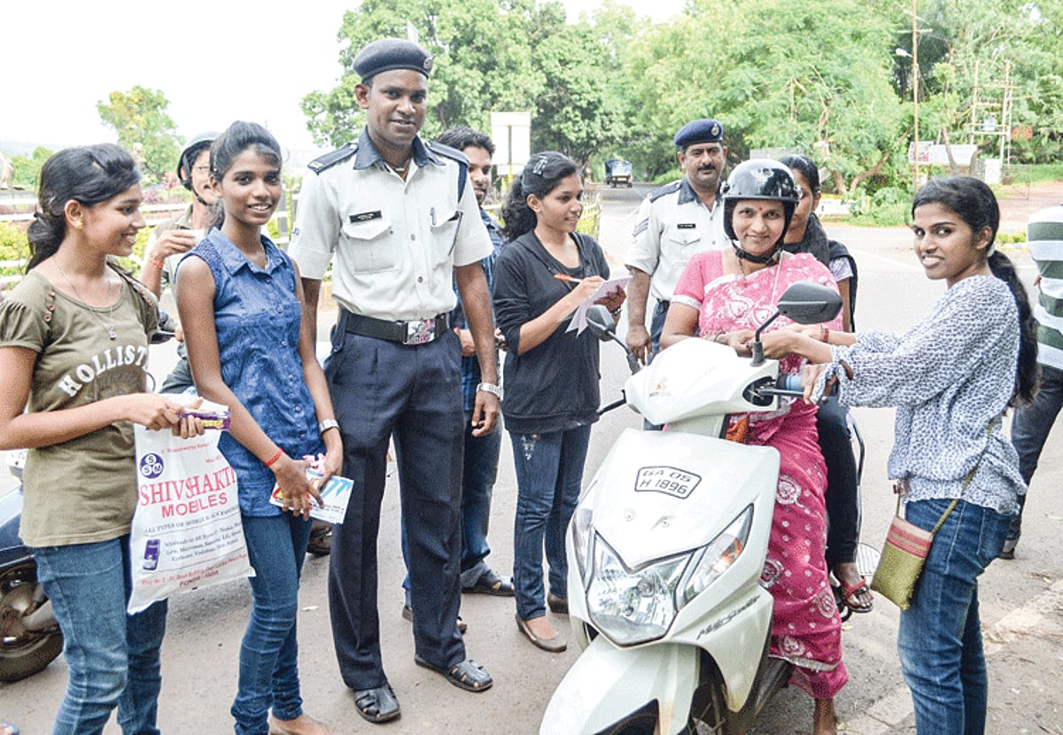 A volunteer from the Rotaract Club of Ponda greets a two-wheeler rider at the Farmagudi circle in Ponda during the appreciation drive.