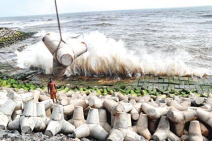 A wave hits the Anjuna coastline on Saturday as a tetrapod is lowered to be placed among other tetrapods