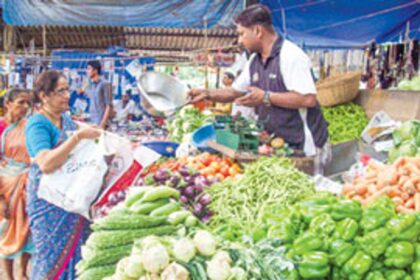 A woman purchases vegetables in the Ponda market on Wednesday.