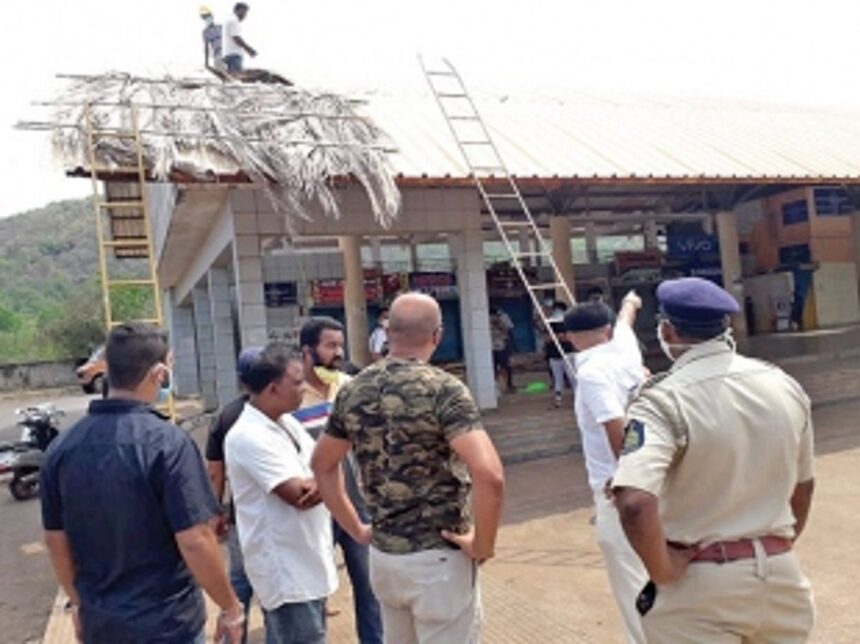 Activists thatch roof of Canacona bus stand with palm leaves