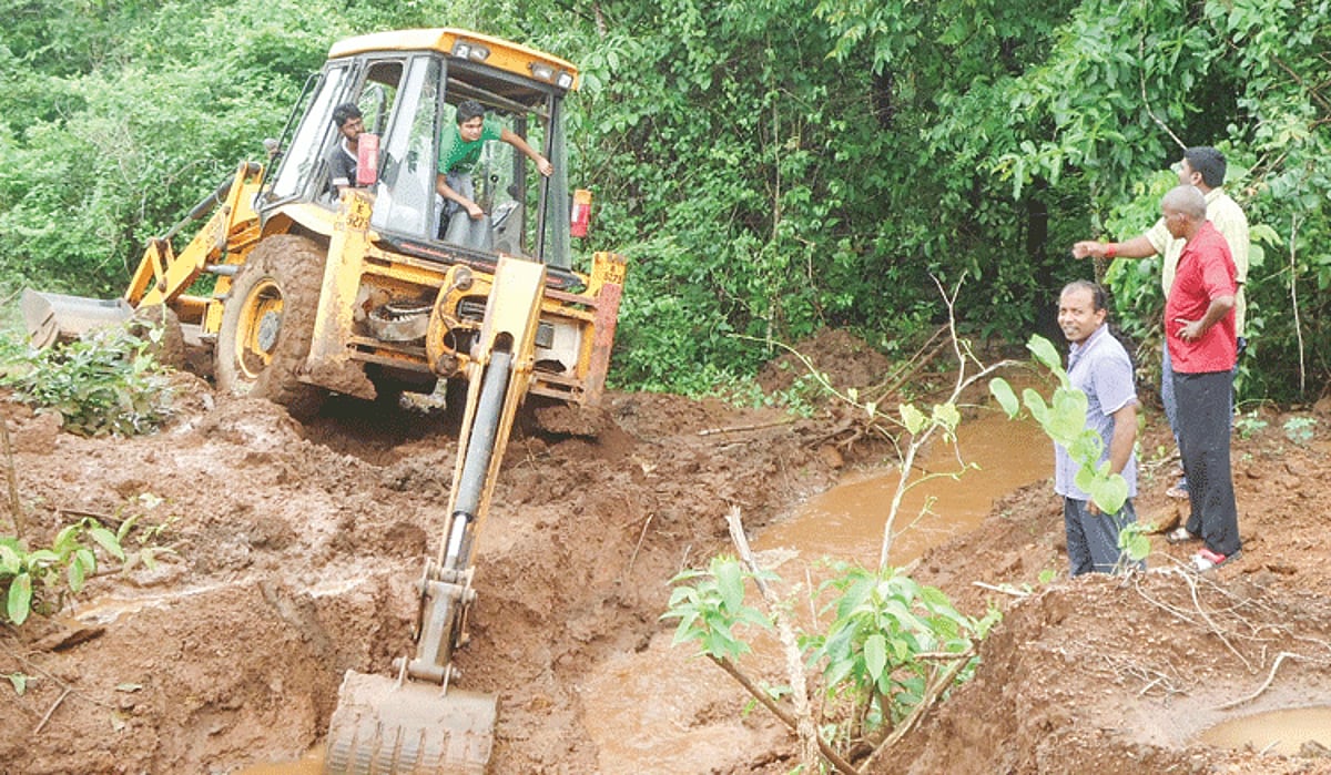 An earthmover digs a water drain to divert the flow of water at Uguem-Sanguem