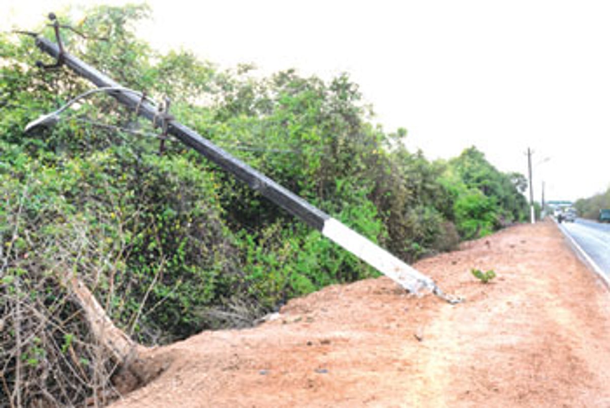 An electric pole lies damaged and tilted on its side