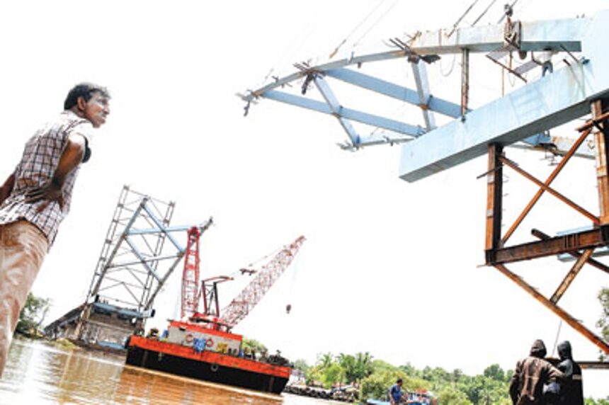 An onlooker looks at the main arch of the Corjuem-Calvim Bridge being constructed