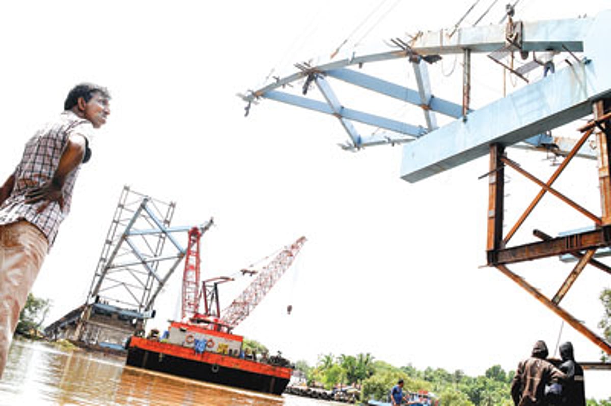 An onlooker looks at the main arch of the Corjuem-Calvim Bridge being constructed