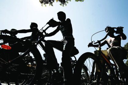 Art students, with slogans painted on their bodies to promote communal harmony, cycle through the streets of Bangalore on Friday.
