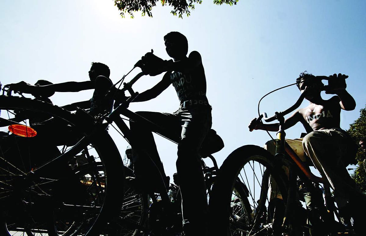 Art students, with slogans painted on their bodies to promote communal harmony, cycle through the streets of Bangalore on Friday.