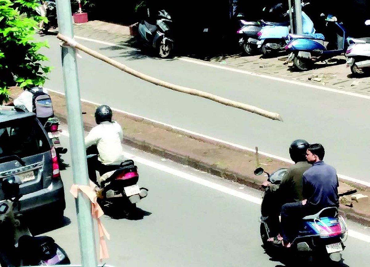Bamboo stick hangs precariously from electricity pole