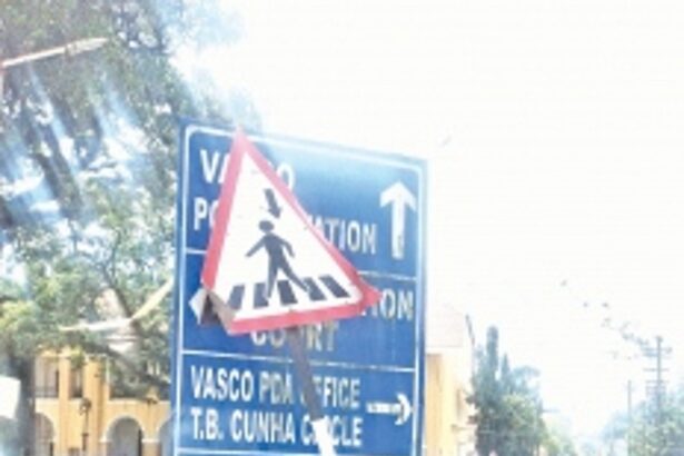 Bent road-sign covers another sign showing direction