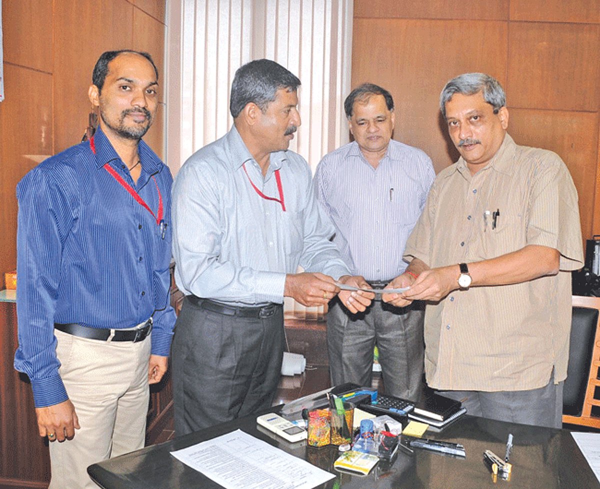 Chief Minister Manohar Parrikar receiving a Demand Draft of Rs 1,00,000 from Secretary, Department of Sainik Welfare, Major Venugopal Nair (Retd) towards the Uttarakhand Relief Fund at Porvorim. Also seen are Addl Secretary (Home), Sanjiv Gadkar and Dire