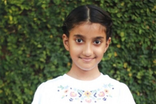 Clasping the racquet in her little hands…