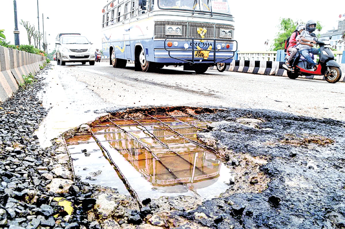 Deadly trap:A mini bus entering the capital city is reflected in a large pothole exposing the iron rods on the new Patto Bridge.