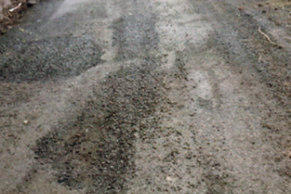 Despite showers, black topping of road in Bhati continues