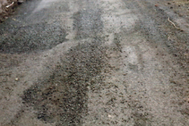 Despite showers, black topping of road in Bhati continues