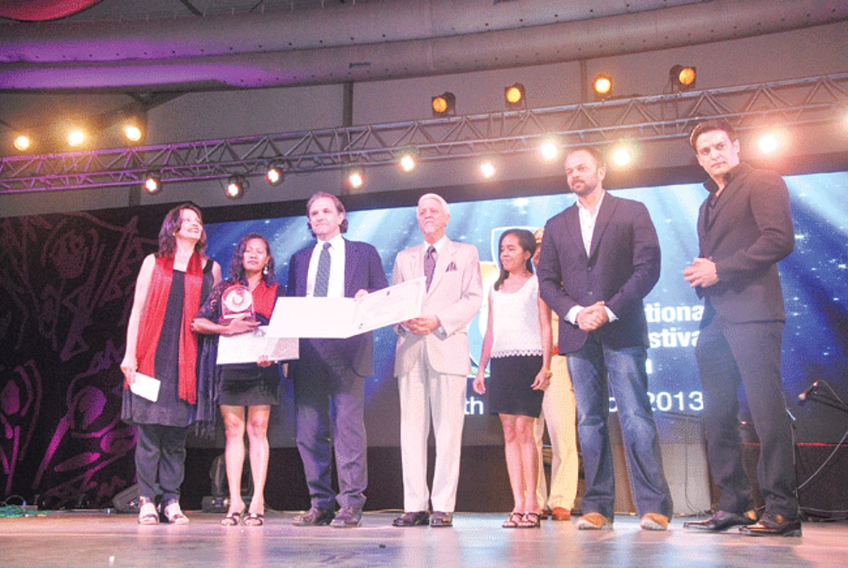 Directors Luigi Acquisto, Bety Reis and actor/writer Irim Tolentino receiving the Golden Peacock award from the Governor Bharat Vir Wanchoo.