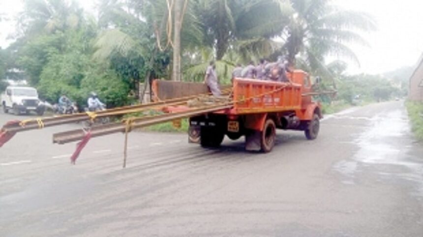 Electricity Dept continues to carry poles on truck 1 Electricity Dept continues to carry poles on truck