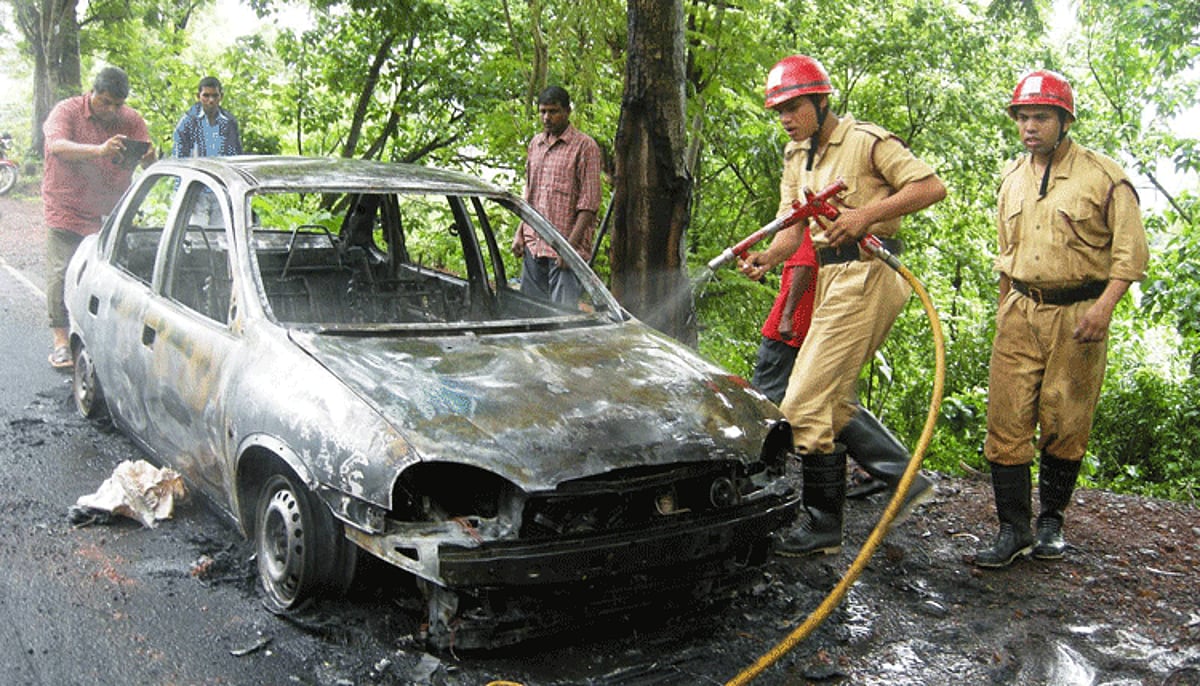 Fire personnel extinguishing the car fire.