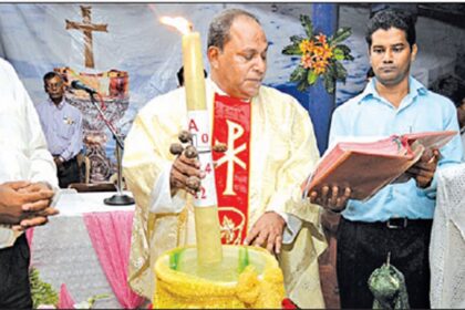 Fr Oscar Quadros dips the Paschal Candle in holy water during the Easter vigil services at Clergy Home, Porvorim to mark the resurrection of Jesus Christ.