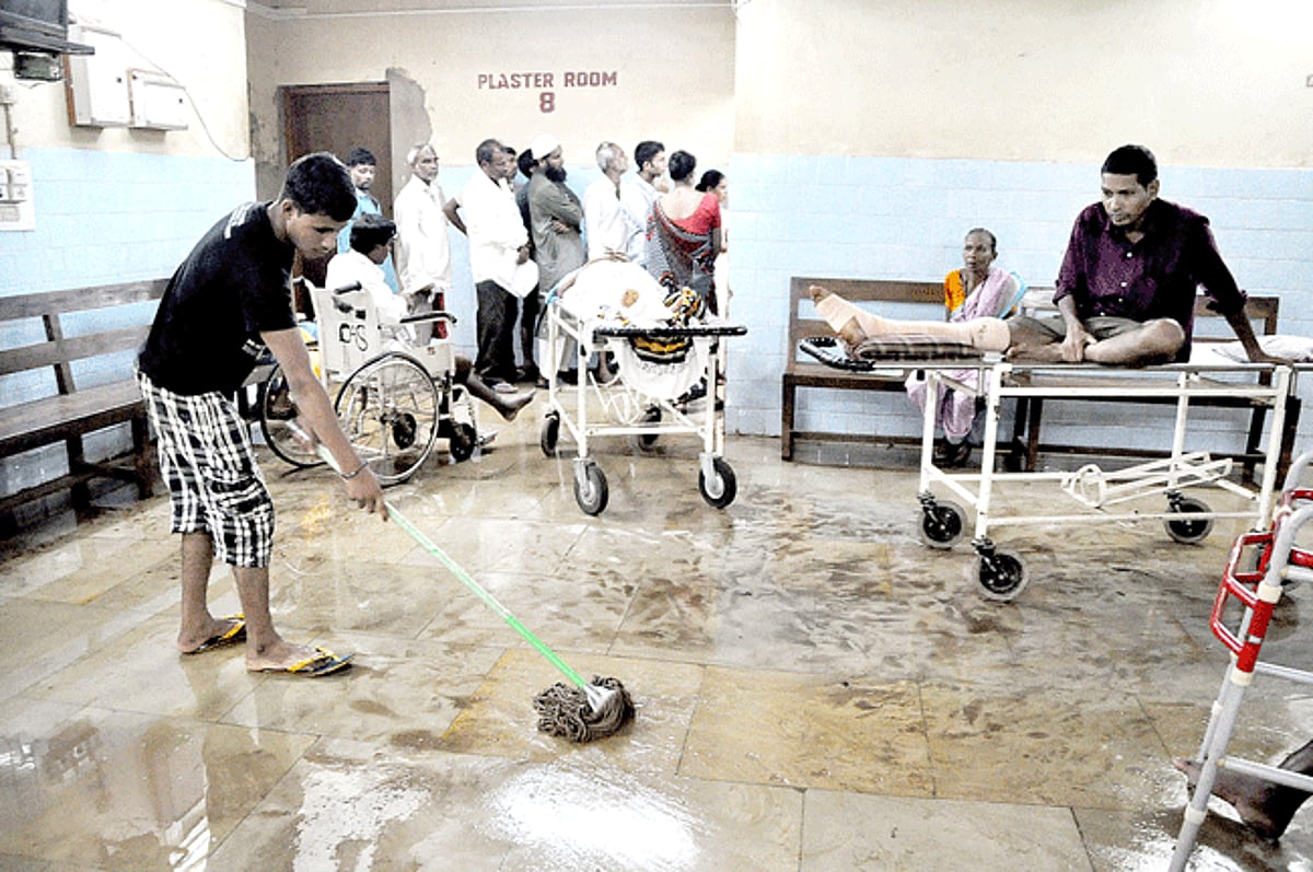 INFECTED: A patient looks on as a labourer mops a section of the water-logged OPD 7 of Goa Medical College hospital at Bambolim on Tuesday.