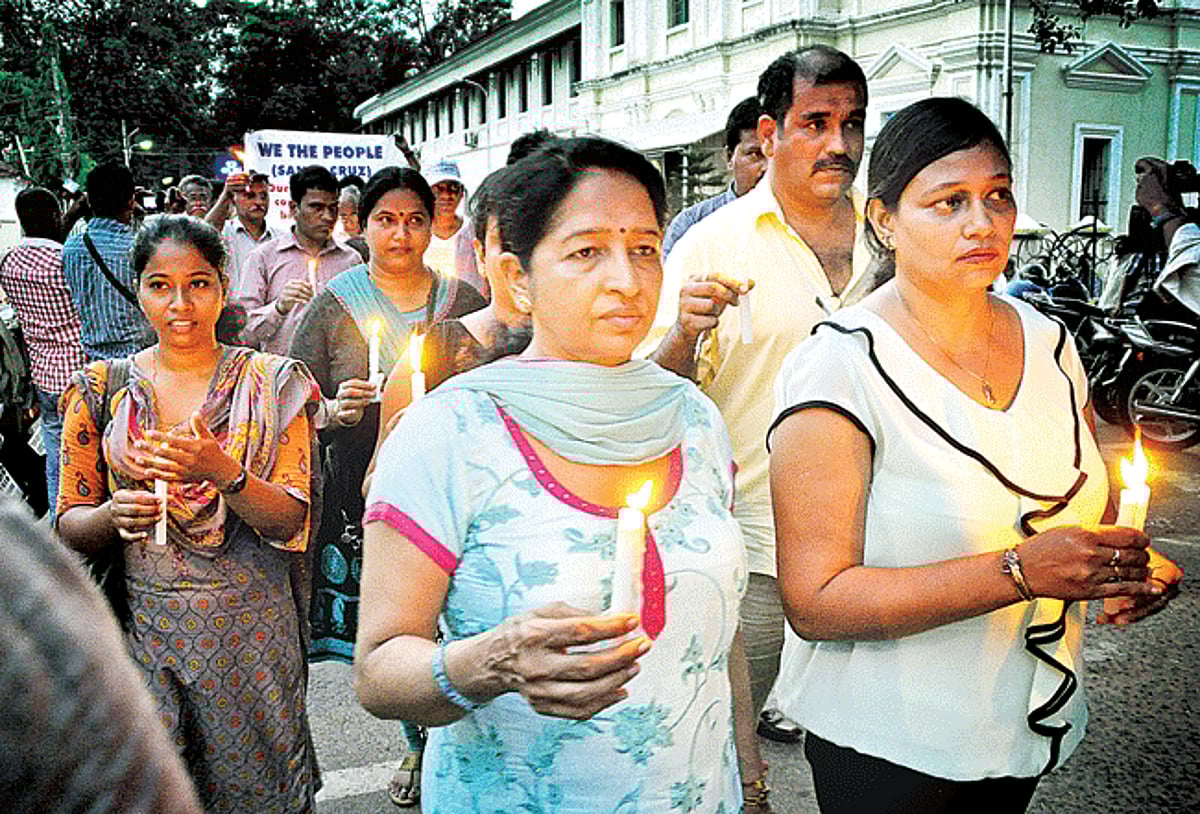 In memory of: Residents of Santa Cruz participate in a candle light march to protest the murder of 69-year old women at St. Agostinho ward at Santa Cruz on Wednesday.