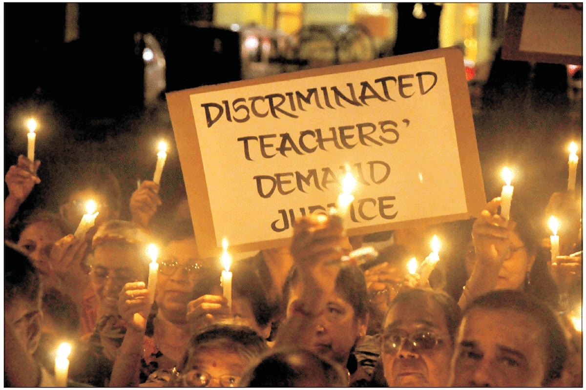 LIGHTING THEIR PLIGHT: Retired teachers sunder the banner of Discrimnated Teachers' Forum lit candles to highlight their grouse.