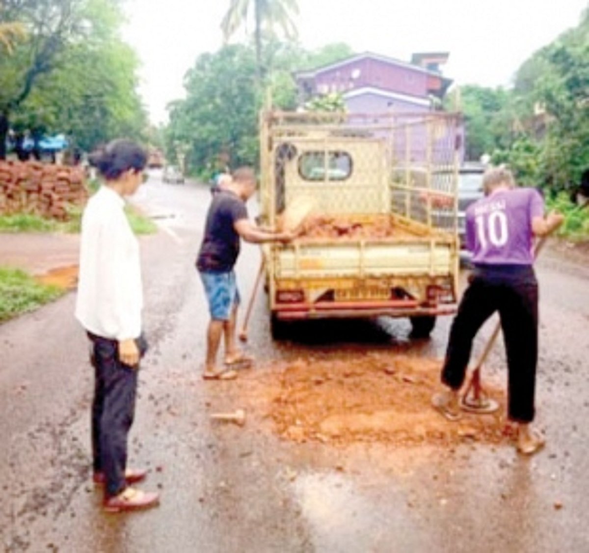 Lawyer with locals fills potholes at her expense