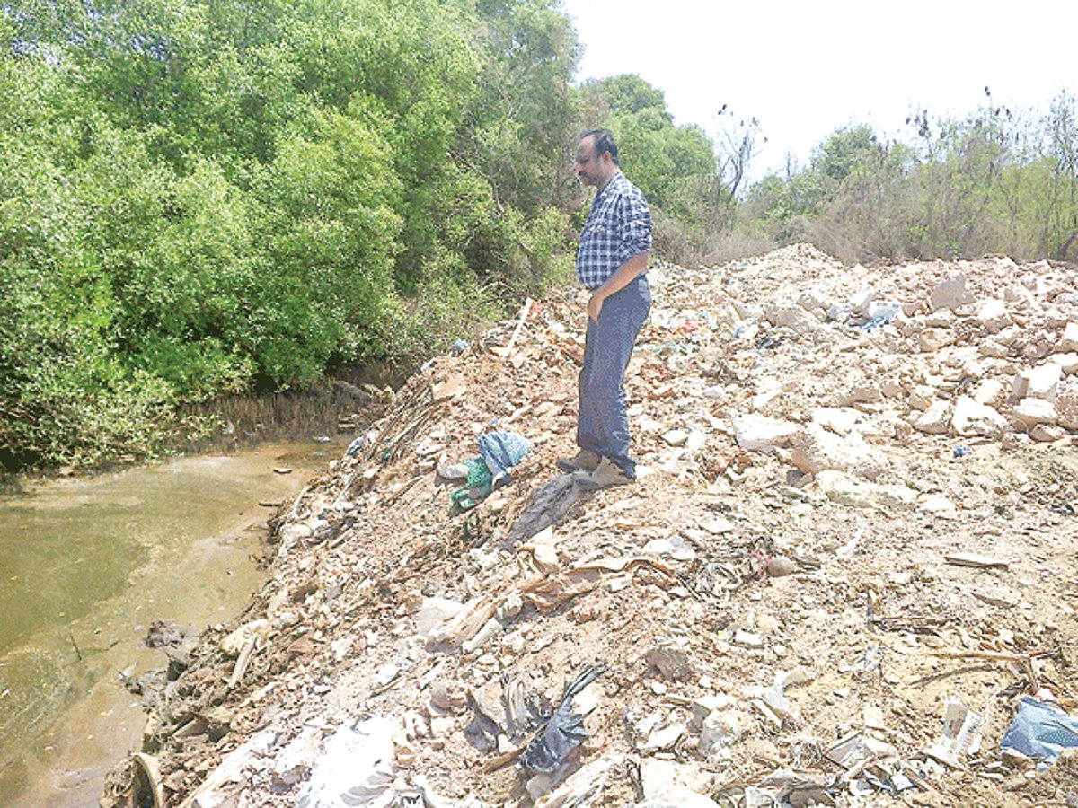 Merces Sarpanch Yateen Palekar at the site where construction debris was dumped.